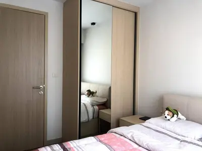 a bedroom with two beds and a large mirror at SHADE of Sky Sathon - Pool, Fitness, Parking, Wifi in Bangkok