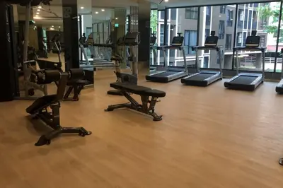 a gym with treadmills and ellipticals in a room at SHADE of Sky Sathon - Pool, Fitness, Parking, Wifi in Bangkok