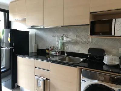 a kitchen with a sink and a microwave and a dishwasher at SHADE of Sky Sathon - Pool, Fitness, Parking, Wifi in Bangkok