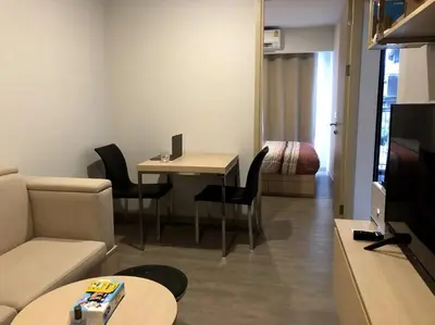 a living room with a couch and a table with chairs at SHADE of Sky Sathon - Pool, Fitness, Parking, Wifi in Bangkok