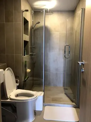 a bathroom with a toilet and a glass shower at SHADE of Sky Sathon - Pool, Fitness, Parking, Wifi in Bangkok