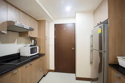 a kitchen with a refrigerator and a microwave at Harmony Living Condominium in Makkasan