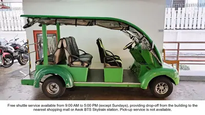 a green golf cart parked in a parking lot at Harmony Living Condominium in Makkasan