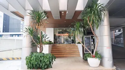 a lobby with palm trees in a building at Harmony Living Condominium in Makkasan