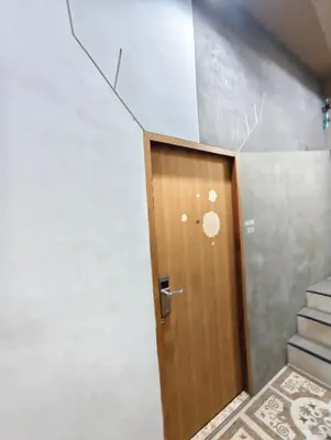 a wooden door in a room with stairs at Hive28 in Bang Kapi