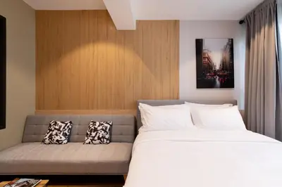 a bedroom with a bed and a couch at โรงแรมอินฟินิทเกษตร in Ban Yang