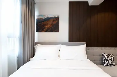 a bedroom with a bed with white pillows at โรงแรมอินฟินิทเกษตร in Ban Yang