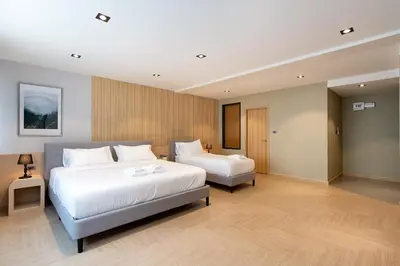 a hotel room with two beds in a room at โรงแรมอินฟินิทเกษตร in Ban Yang