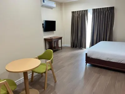 a hotel room with a bed and a table and chairs at Anwari Hotel in Bangkok