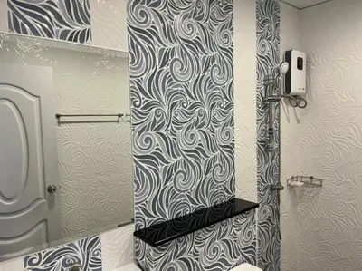 a bathroom with a shower with a mirror and a toilet at Anwari Hotel in Bangkok