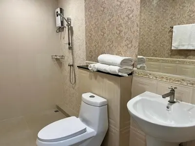 a bathroom with a toilet and a sink at Anwari Hotel in Bangkok
