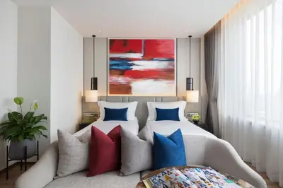 a bedroom with a bed and a couch with colorful pillows at Ascott Embassy Sathorn Bangkok in Bangkok