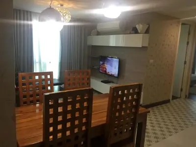 a living room with a table and chairs and a television at Liv at 5 room41 in Bangkok