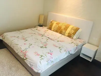 a bedroom with a bed with a floral bedspread and a pillow at Liv at 5 room41 in Bangkok