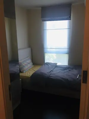a small room with a bed and a window at Liv at 5 room41 in Bangkok