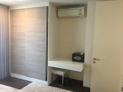 a bedroom with a closet with a desk and a heater at Liv at 5 room41 in Bangkok