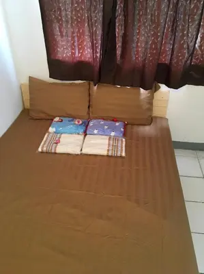 a bed in a room with a brown bedspread and a window at 5บีบี 5BB guest house in Bangkok