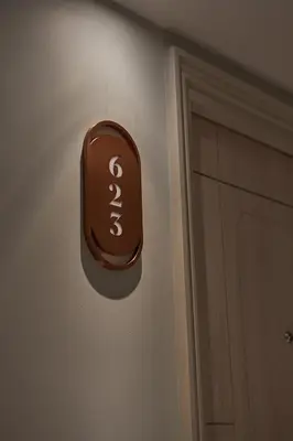 a brown sign on a wall next to a door at The Path Siam in Bangkok