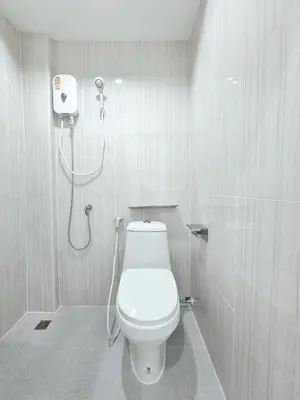 a bathroom with a toilet and a shower at The zai Apartment in Ban Krathum Lom