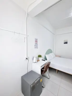 a white room with a bed and a desk at The zai Apartment in Ban Krathum Lom