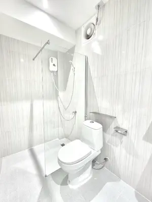a white bathroom with a shower and a toilet at The zai Apartment in Ban Krathum Lom