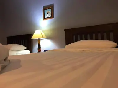 a bedroom with a large bed with a lamp and a bed sidx sidx at Mango Bedroom Inn in Bangkok