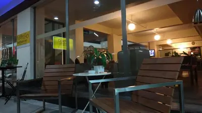 two chairs and a table in front of a restaurant at Mango Bedroom Inn in Bangkok