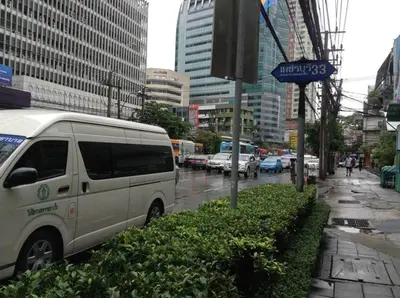 a white van parked on the side of a city street at Mango Bedroom Inn in Bangkok