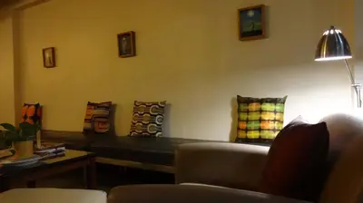 a living room with a couch and pillows on the wall at Mango Bedroom Inn in Bangkok