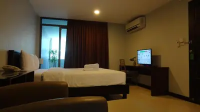 a hotel room with a bed and a television at Mango Bedroom Inn in Bangkok