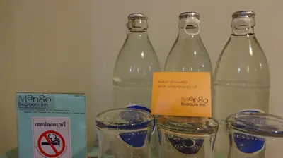 a group of four bottles of water and glasses at Mango Bedroom Inn in Bangkok