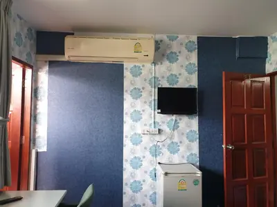 a bathroom with a toilet and a heater on the wall at Room For You in Bangkok