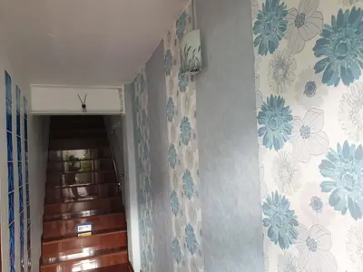 a hallway with blue and white flowers on the wall at Room For You in Bangkok