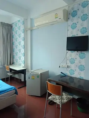a room with a desk and a table and a refrigerator at Room For You in Bangkok