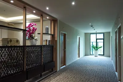 a hallway of a home with flowers in at Almas Hotel Bangkok in Bangkok