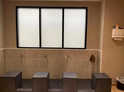 a bathroom with three stools and a large window at Almas Hotel Bangkok in Bangkok