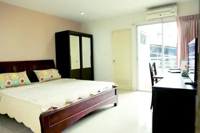 a bedroom with a bed and a desk and a window at Mee sook Hotel and Residence in Nonthaburi