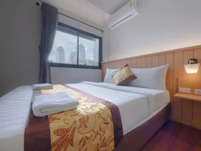 a bedroom with a large bed with a window at Watergate City in Bangkok