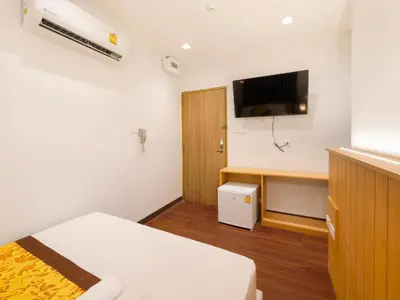 a room with a bed and a desk and a tv at Watergate City in Bangkok