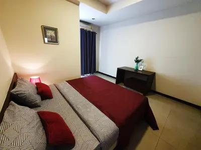 a bedroom with a large bed with a red blanket at 552 Residence in Bangkok