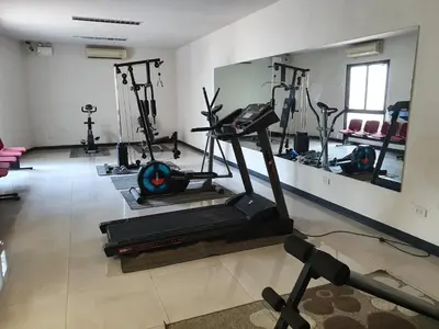 a gym with several tread machines and a mirror at 552 Residence in Bangkok