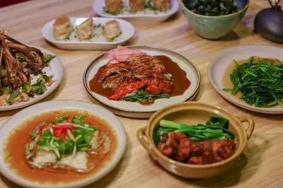 a wooden table with plates of food on it at Seekers Finders Rama IV Hotel SureStay Collection by BW in Bangkok