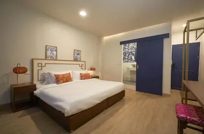 a bedroom with a large bed and a blue door at Sweet's Escape in Bangkok