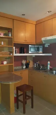 a kitchen with wooden cabinets and a table in it at The Park Land Bangna by Nudda in Bangkok