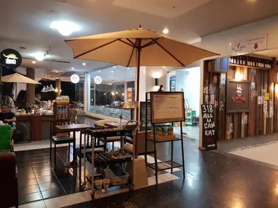 a restaurant with a table and an umbrella in a store at The Park Land Bangna by Nudda in Bangkok