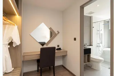 a bathroom with a desk with a mirror and a toilet at Thaya Hotel Bangkok in Bangkok