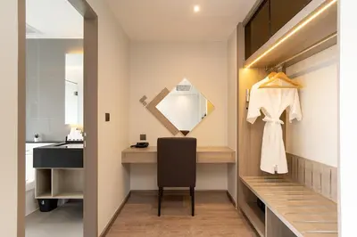 a dressing room with a vanity and a mirror at Thaya Hotel Bangkok in Bangkok