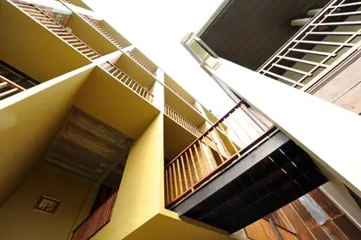 a yellow building with stairs and a balcony at Villa Bangkok in Bangkok