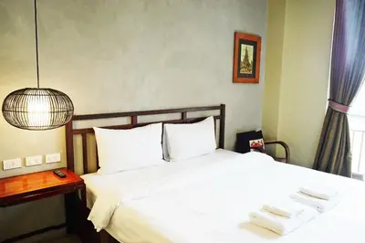 a bedroom with a white bed with towels on it at Villa Bangkok in Bangkok