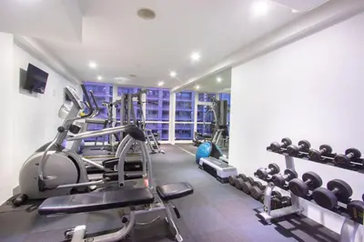 a gym with treadmills and machines in a room at Hotel Icon Bangkok Sukhumvit 2 in Bangkok